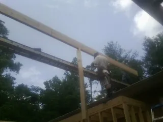 Carpenter setting a ridge beam over a new addition frame — Ice Dam Removal by Roofing Brothers in Grandview